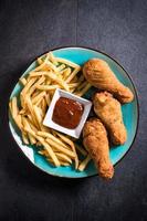 Fried chicken legs and French fries photo