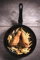 francés papas fritas y pollo piernas foto