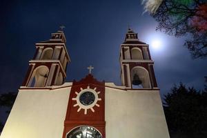 Church at night with a light. San Miguel de las Casitas Xichu Guanajuato Mexico photo