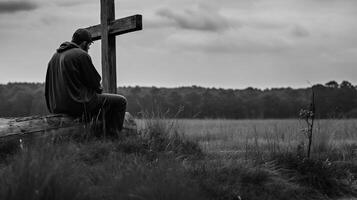 hombre en frente de un de madera cruzar en el campo. negro y blanco. ai generado obra de arte foto