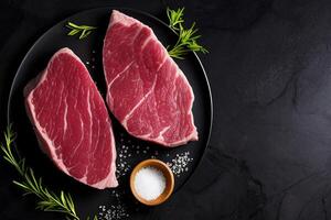 The raw steak on the black background with . photo