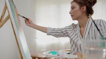 beaux passe-temps féminins sur l'artiste et utiliser le pinceau dans l'art abstrait pour créer un chef-d'œuvre. peinture de peintre à l'aquarelle ou à l'huile dans la maison de studio. aime peindre comme passe-temps, loisir, inspiration video