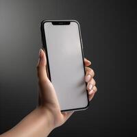 hand holding smartphone with blank screen on gray background. Mock up , photo