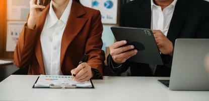 hombre de negocios y equipo analizando la tarea financiera de los estados financieros. con teléfono inteligente y computadora portátil y tableta. concepto de gestión de riqueza foto