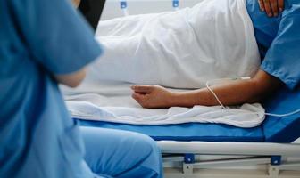 The patient's hand is in bed in the hospital. photo