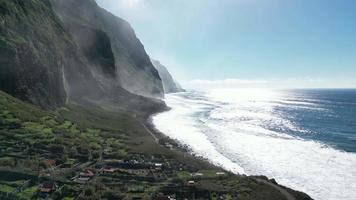 Antenne von das schaumig Wellen von das Meer Schlagen das Ufer und das Klippen auf Madeira Insel, Portugal video