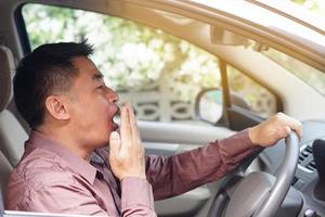 Asian man yawn in car, feels asleep while driving. Concept, campaign to stop driving  with drunk, fatigue exhausted, sick  unwell symptoms or negative feelings that can cause car accident. photo