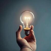 hand holding a lightbulb on a dark background, idea concept photo