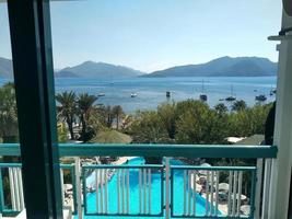 View from the balcony to the sea and palm trees . Landscape. Sunny Day. Terrace with a beautiful view. Background with beautiful landscape. Mounths near the sea. photo