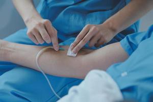 Injured patient showing doctor broken wrist and arm with bandage in hospital office or emergency room. Sprain, stress fracture or repetitive strain injury in hand. Nurse helping customer. First aid. photo
