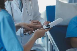 Injured patient showing doctor broken wrist and arm with bandage in hospital office or emergency room. Sprain, stress fracture or repetitive strain injury in hand. Nurse helping customer. First aid. photo