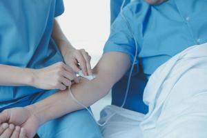 Injured patient showing doctor broken wrist and arm with bandage in hospital office or emergency room. Sprain, stress fracture or repetitive strain injury in hand. Nurse helping customer. First aid. photo