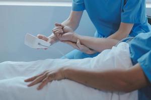 Injured patient showing doctor broken wrist and arm with bandage in hospital office or emergency room. Sprain, stress fracture or repetitive strain injury in hand. Nurse helping customer. First aid. photo