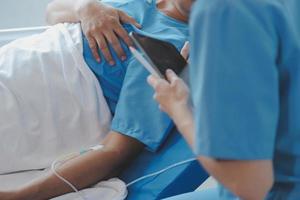 Injured patient showing doctor broken wrist and arm with bandage in hospital office or emergency room. Sprain, stress fracture or repetitive strain injury in hand. Nurse helping customer. First aid. photo