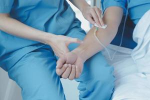 Injured patient showing doctor broken wrist and arm with bandage in hospital office or emergency room. Sprain, stress fracture or repetitive strain injury in hand. Nurse helping customer. First aid. photo