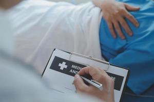 lesionado paciente demostración médico roto muñeca y brazo con vendaje en hospital oficina o emergencia habitación. esguince, estrés fractura o repetitivo presion lesión en mano. enfermero Ayudar cliente. primero ayuda. foto