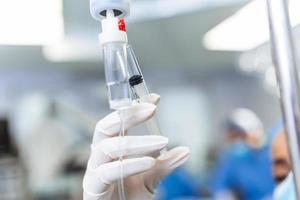 African american female Doctor in the operating room putting drugs through an IV - surgery concepts photo