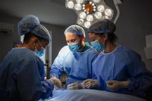 Surgeons performing operation in operation theater. breast augmentation surgery in the operating room surgeon tools implant. Medical care concept. photo