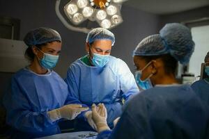 Surgical team performing surgery in modern operation theater,Team of doctors concentrating on a patient during a surgery,Team of doctors working together during a surgery in operating room, photo