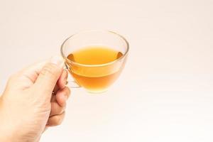 Glass cup of hot ginger tea isolated on white background. photo