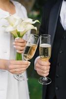 Close-up of the hands of the bride and groom with glasses of champagne photo