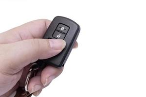 Hand of man holding and pushing black remote control of car isolated on white background with free space for adding some text on the right photo