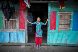 Bangladesh June 27, 2015 A girl is standing at their door whose house was destroyed of massive river erosion at Rasulpur, Barisal District. photo