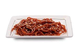 Seasoned dried shredded squid ojingeochae muchim with sesame in dish isolated on white background with clipping path photo