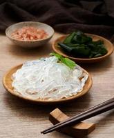 clear kelp or seaweed noodle in a wooden plate and Himalayan salt on wooden background. glass noodle photo