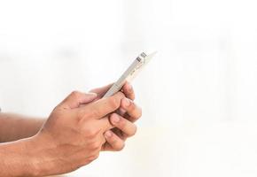 Asian man hand holding Smartphone isolated on white background. man hand holding Smartphone with a black screen isolated on white background. Smartphone mock up or blank background photo