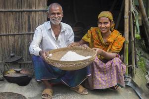 Bangladesh febrero 09, 2018 un pueblo hombre y mujer mostrando khoi hinchado arroz desde binni Dhan cáscara glutinoso arroz como bengalíes tradicional festivales comidas a sabar, dhaka. foto
