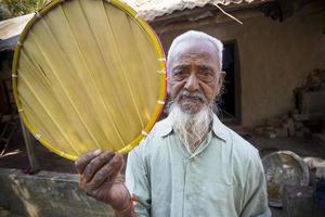 Bangladesh febrero 15, 2018 un antiguo artesano muestra su hecho a mano Palmira hoja ventilador a bogura, bangladesh foto