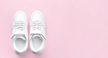 White sneakers on a pink background. photo