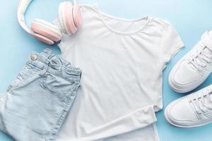 Child's t-shirt, shoes and headphones on blue backgrund photo