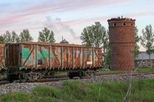 Wagons filled with slate and an old red brick water tower. photo