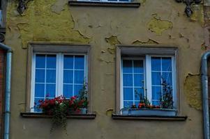 interesting windows in old historic tenement houses in the Polish city of Gdansk close up photo