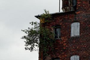 interesting windows in old historic tenement houses in the Polish city of Gdansk close up photo