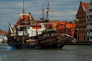 histórico retro turista navegación barco entrando el polaco ciudad de gdansk foto