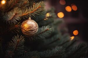 Close up view of beautiful fir branches with shiny gold bauble or ball, xmas ornaments and lights, christmas holidays background. . photo