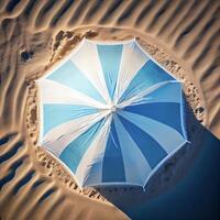 azul y blanco paraguas sentado en parte superior de un arenoso playa. generativo ai. foto