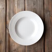 An empty plate on a white wooden table. Top view of white ceramic plate on white wooden. . photo