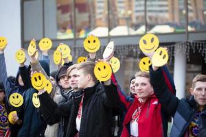 Many people hold emoticons in their hands. photo