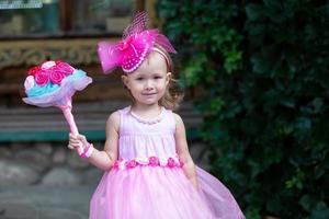 Brides parade.Beautiful little girl in a pink dress with a bouquet of flowers. photo