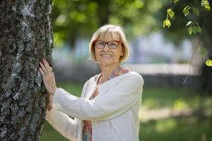 retrato de un hermosa mayor mujer en el parque. europeo abuela. foto