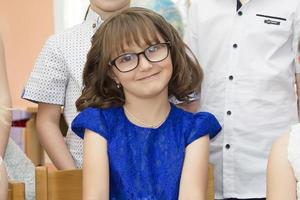 el cara de un niña de elemental años con lentes. foto