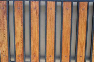 Photo of a symmetrical brown and black iron picket fence