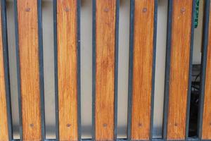 Photo of a symmetrical brown and black iron picket fence