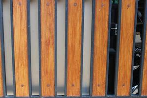 Photo of a symmetrical brown and black iron picket fence