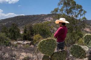 Man with a cowboy hat looking at the abandoned house of his grandparents in Mexico photo