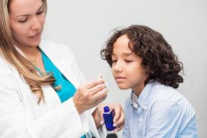 Doctor giving a child homeopathic medicine photo